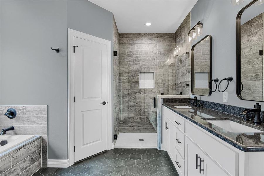 Bathroom featuring double vanity, tile flooring, and shower with separate bathtub