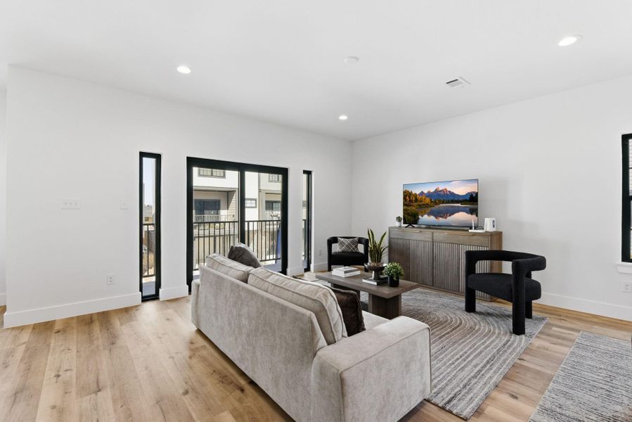 Sleek sliding doors opening to a private balcony, filling the space with natural light. Sleek sliding doors opening to a private balcony, filling the space with natural light.
