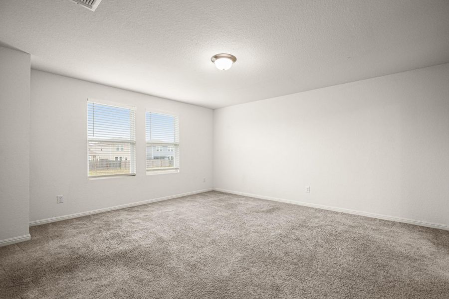 Empty room with a textured ceiling and light carpet