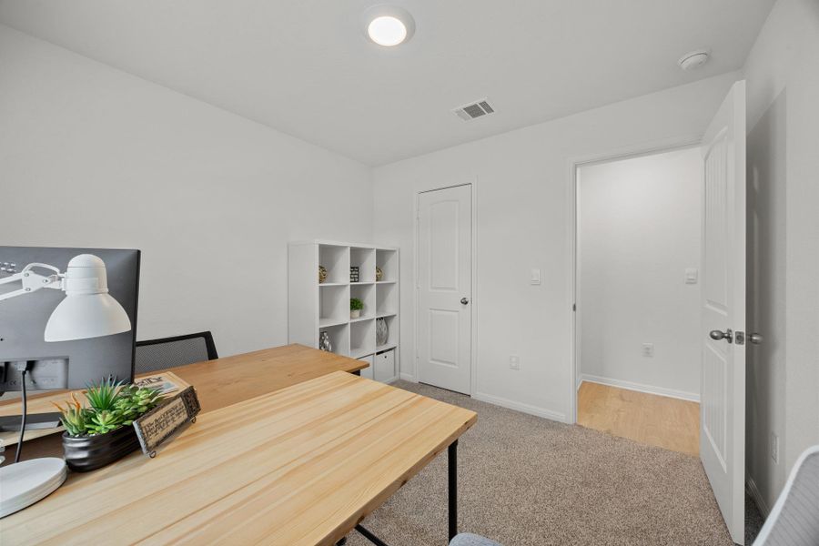 Office area featuring baseboards and light carpet