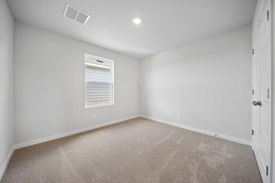 A well-proportioned bedroom with soft carpet and a simple window. A well-proportioned bedroom with soft carpet and a simple window.