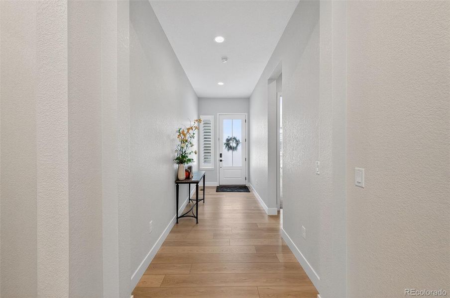 Entryway – A bright, inviting foyer with wide-plank wood flooring and soft neutral tones sets the tone for the home’s elegant interior design.