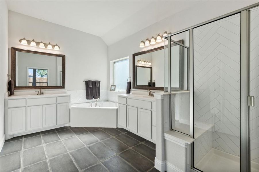 Bathroom featuring lofted ceiling, a wealth of natural light, and separate shower and tub,
