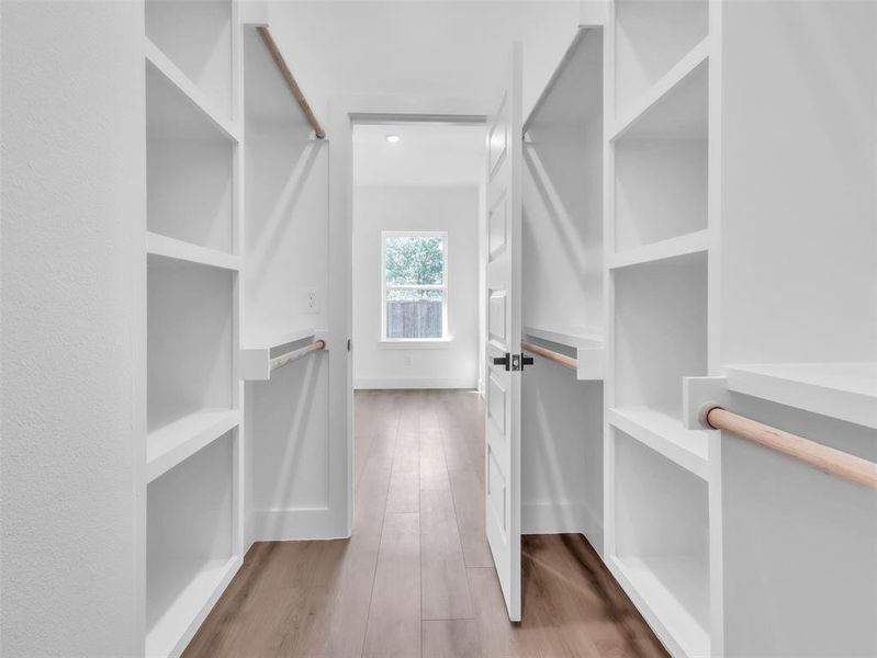 Walk in closet featuring wood finished floors Walk in closet featuring wood finished floors
