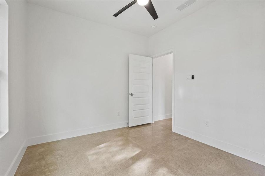 Unfurnished room featuring concrete flooring and ceiling fan