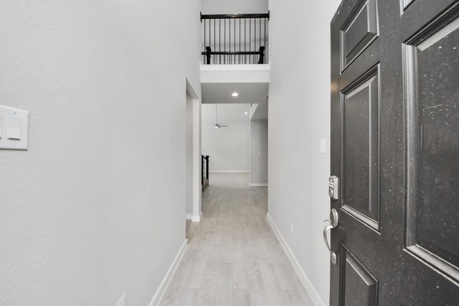 As you step into the threshold of this luxurious home, you'll soon be welcomed by an elegant glass door (to be installed). Inside, soaring ceilings amplify the spaciousness, while the refined wood-look tile flooring and oversized baseboards exude sophistication and charm. Sample photo of completed home with similar floor plan. Actual colors and selections may vary.