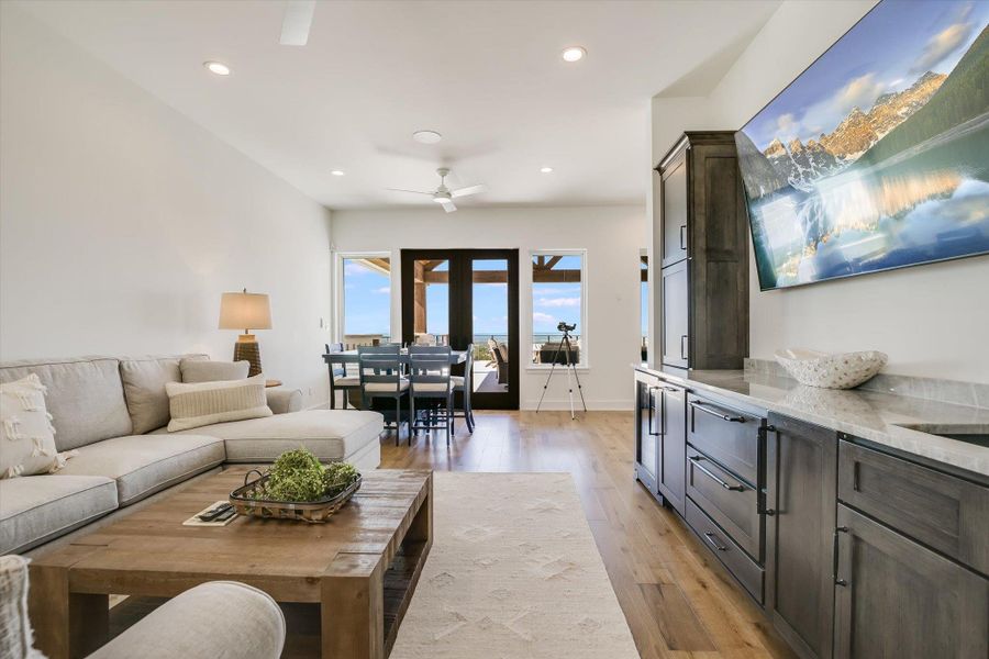 Living area featuring light wood-style floors, ceiling fan, recessed lighting, and baseboards Living area featuring light wood-style floors, ceiling fan, recessed lighting, and baseboards