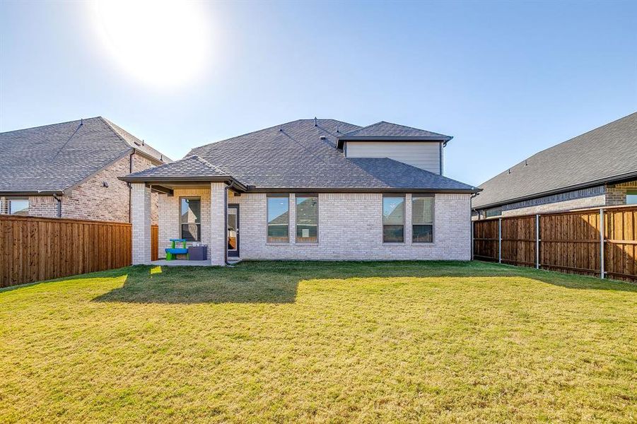 Rear view of house featuring roof with shingles, a patio, brick siding, and a fenced backyard Rear view of house featuring roof with shingles, a patio, brick siding, and a fenced backyard