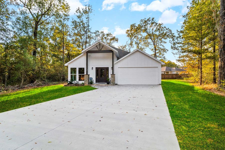 This charming home features a modern design with a white façade and a welcoming front porch. It is surrounded by lush greenery and mature trees, offering privacy and a serene atmosphere. The spacious driveway leads to an attached garage, providing ample parking. This charming home features a modern design with a white façade and a welcoming front porch. It is surrounded by lush greenery and mature trees, offering privacy and a serene atmosphere. The spacious driveway leads to an attached garage, providing ample parking.