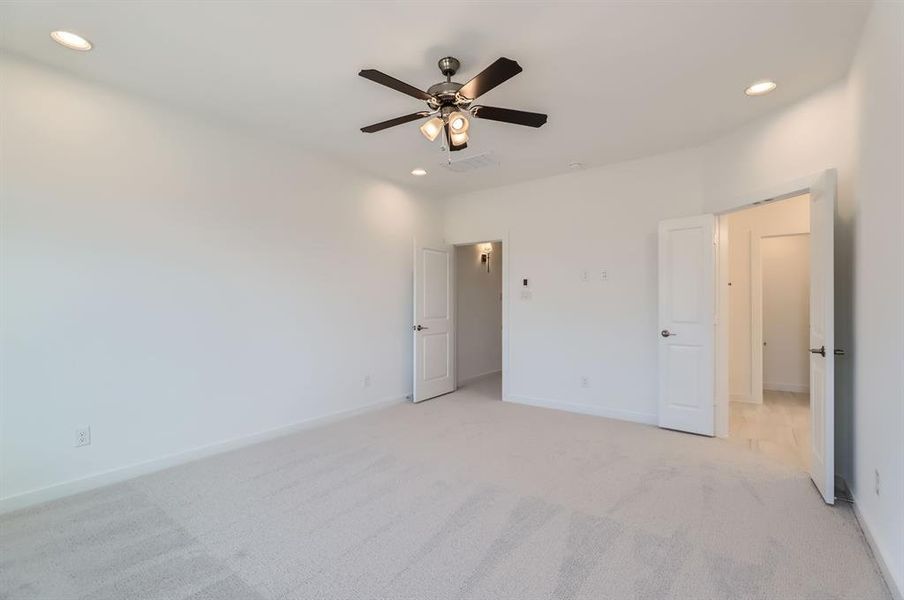 Unfurnished bedroom with light carpet and ceiling fan