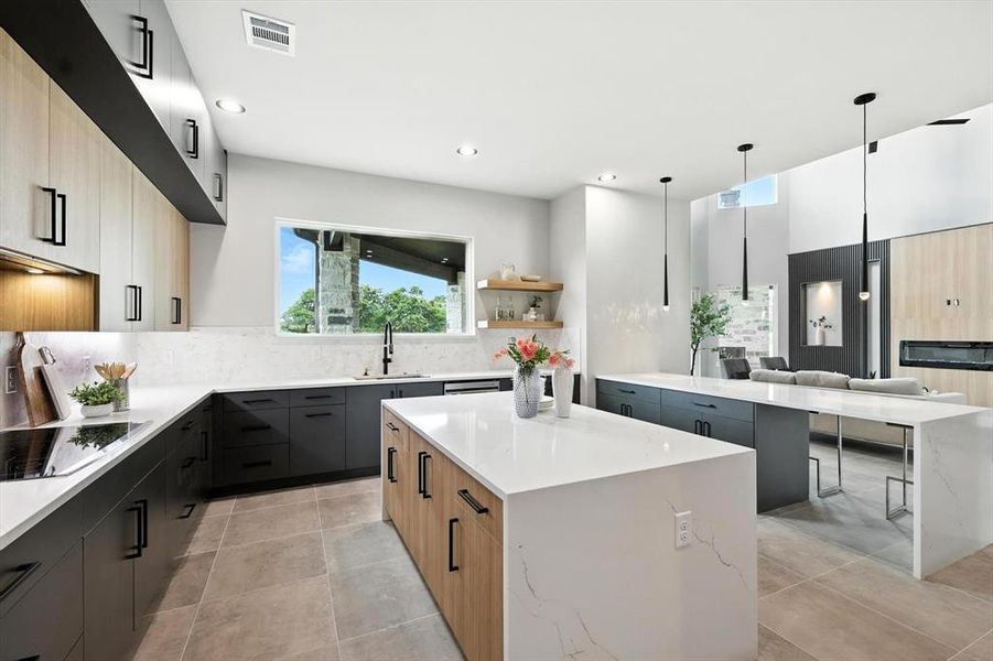 Kitchen featuring black electric stovetop, a center island, modern cabinets, tasteful backsplash, and hanging light fixtures