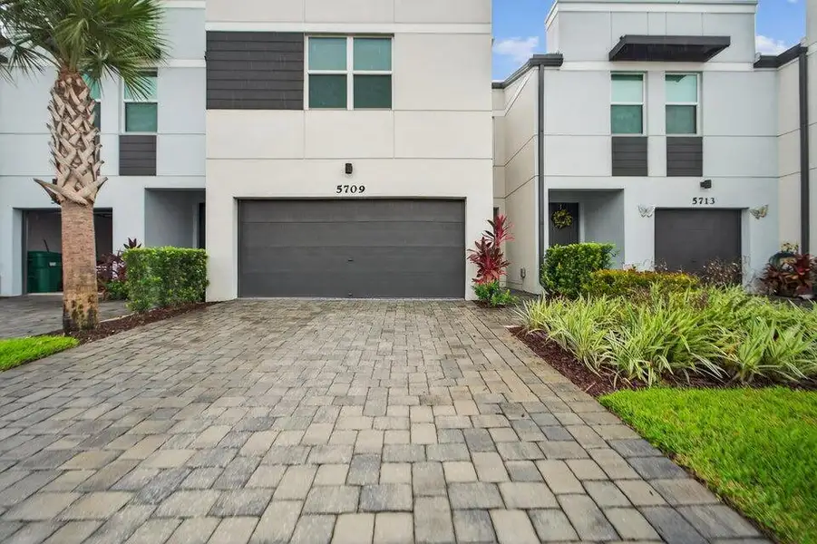 Front exterior of a new home in Enclave at Mangonia Park, West Palm Beach, FL, highlighting curb appeal (Image 1).