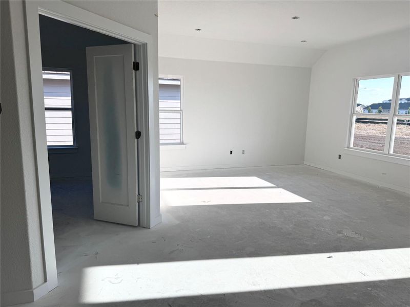 Empty room featuring concrete flooring and lofted ceiling Empty room featuring concrete flooring and lofted ceiling
