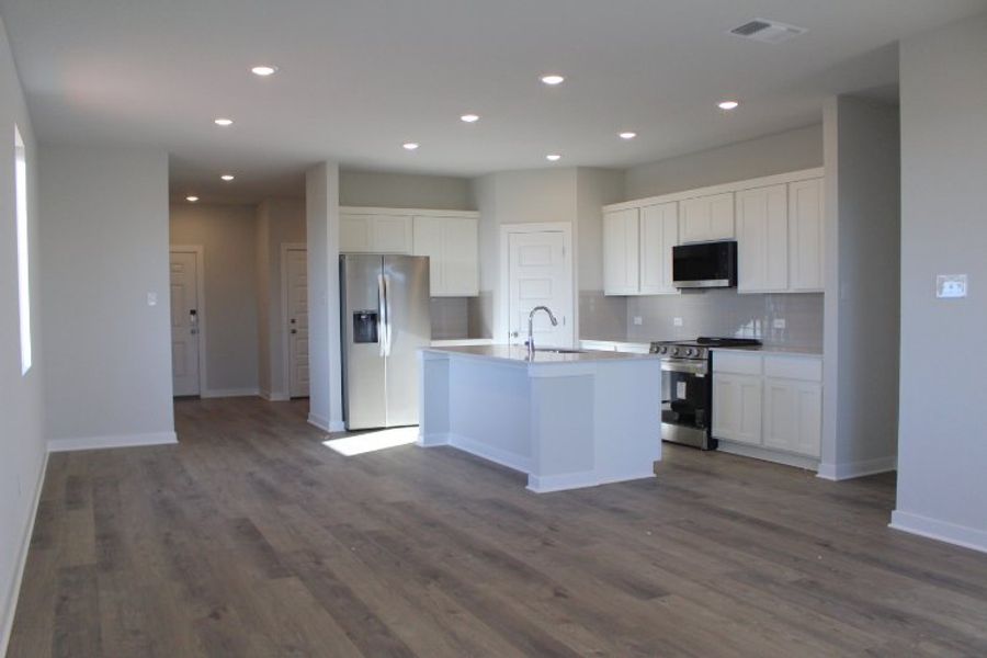 A kitchen with white cabinets.