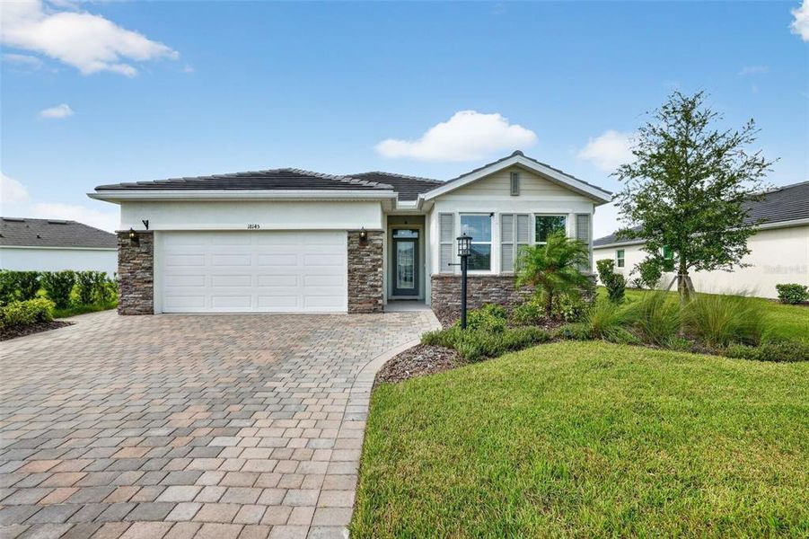 Front exterior of a new home in Star Farms at Lakewood Ranch, Bradenton, FL, highlighting curb appeal (Image 2). Front exterior of a new home in Star Farms at Lakewood Ranch, Bradenton, FL, highlighting curb appeal (Image 2).