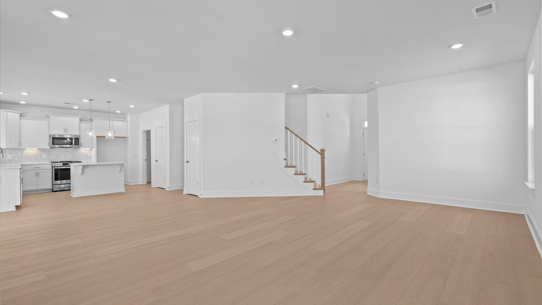 Elegant family room featuring hardwood flooring, large windows, and thoughtful architectural detail