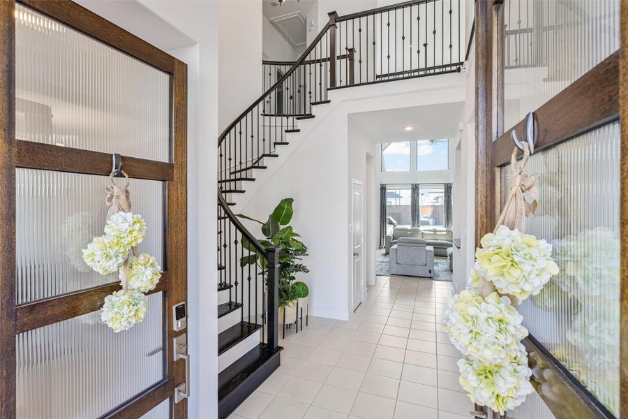 Step into your grand entrance and foyer, where solid wood stairs, abundant natural light, high ceilings, and an elegant iron banister create a stunning first impression.