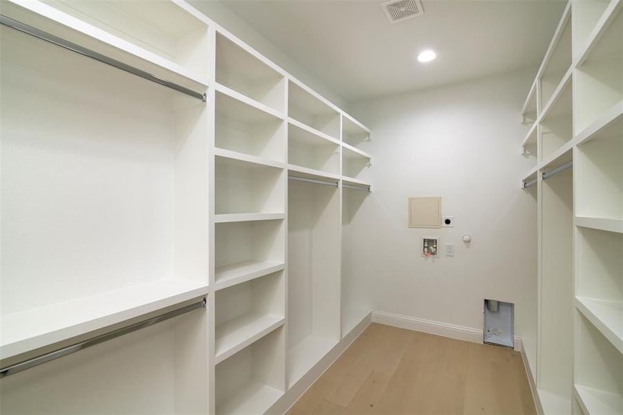 Walk in closet with light wood-type flooring