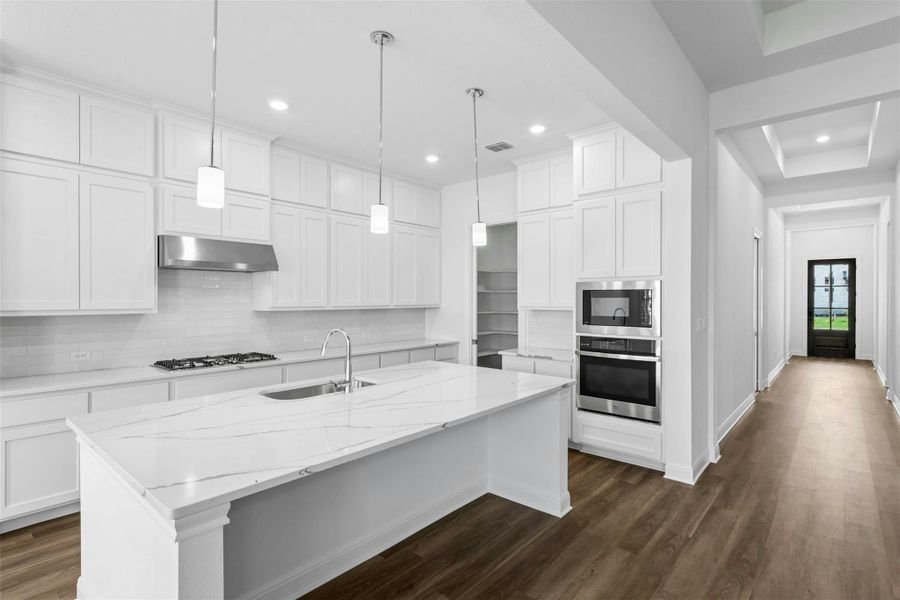 Culinary dreams come alive in this well-appointed kitchen, featuring a spacious island and gleaming stainless steel appliances.