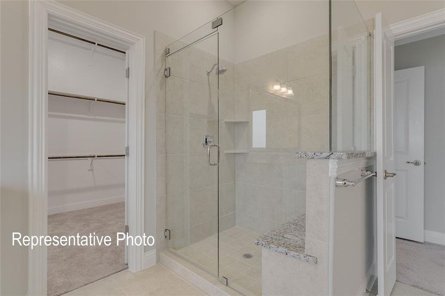 Bathroom featuring tile patterned floors and a shower with door