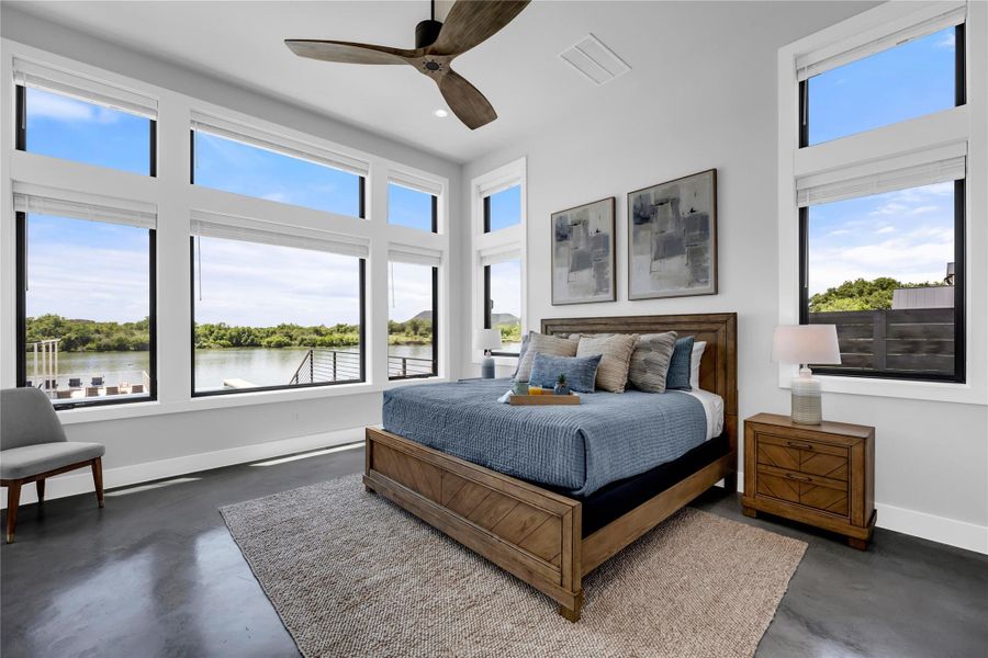 Primary bedroom overlooks a tranquil lake.