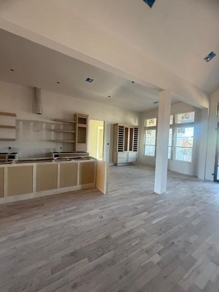 Open floor plan looking into the breakfast room featuring a built-in wine cabinet. White Oak beams will adorne in the kitchen.