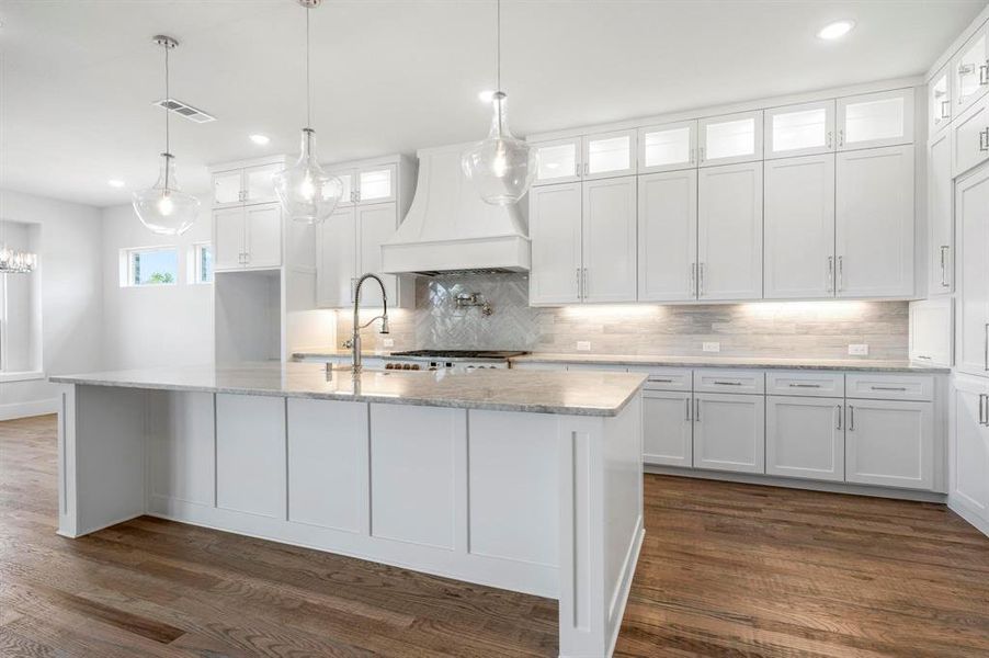 Kitchen featuring white cabinets and premium range hood