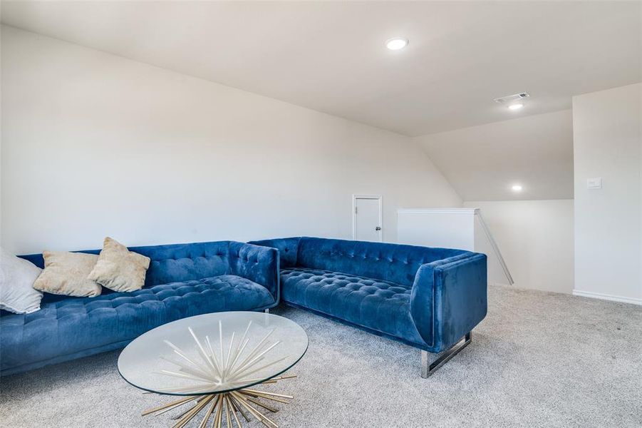 Living room with lofted ceiling, carpet floors, and recessed lighting Living room with lofted ceiling, carpet floors, and recessed lighting