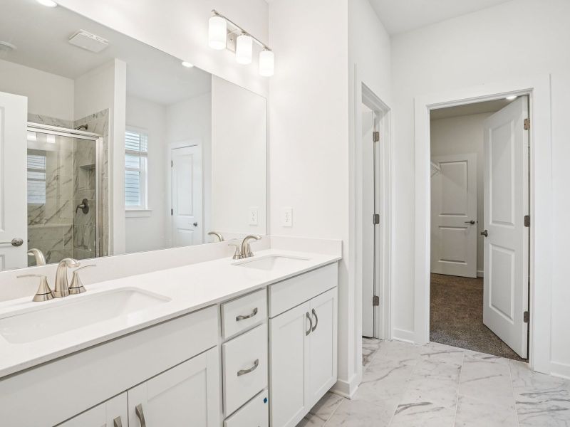 The primary bathroom offers dual vanity sinks and a walk-in shower. The primary bathroom offers dual vanity sinks and a walk-in shower.