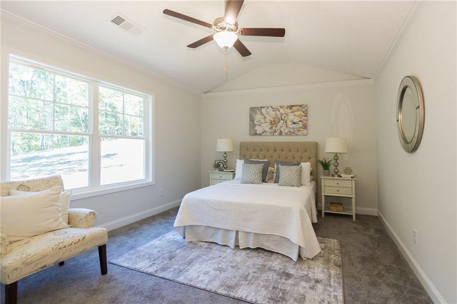 Carpeted bedroom with ornamental molding, lofted ceiling, and ceiling fan