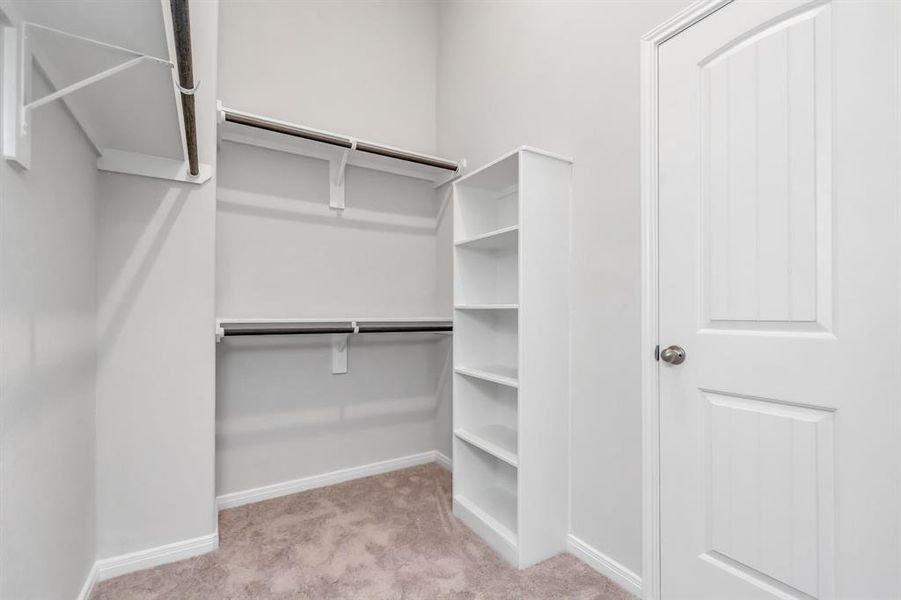 The expansive walk-in closet in the primary bedroom provides ample space for all your wardrobe needs. Custom shelving and rods ensure everything is organized and easily accessible, making it a fashion lover’s dream. **This image is from another Saratoga Home - Wren floorplan.**