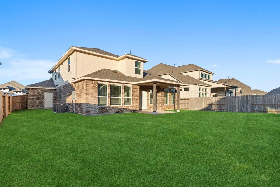 The rear exterior view of the Silverthorne highlights a beautiful blend of brick and wood accents, offering timeless charm and durability. The extended covered patio provides the perfect outdoor retreat for dining, entertaining, or simply relaxing under the Texas sky. The rear exterior view of the Silverthorne highlights a beautiful blend of brick and wood accents, offering timeless charm and durability. The extended covered patio provides the perfect outdoor retreat for dining, entertaining, or simply relaxing under the Texas sky.