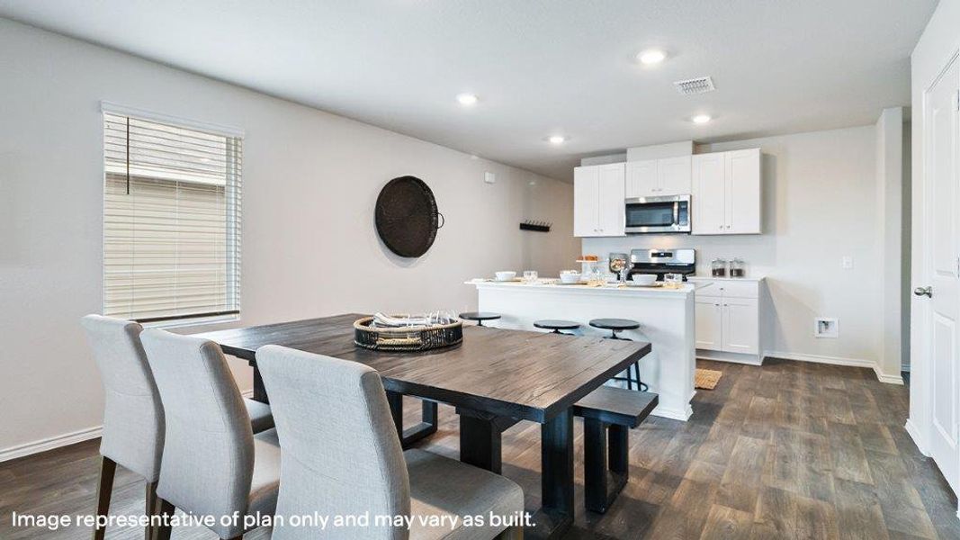 This contemporary kitchen and dining area features sleek appliances and durable wood flooring. This contemporary kitchen and dining area features sleek appliances and durable wood flooring.