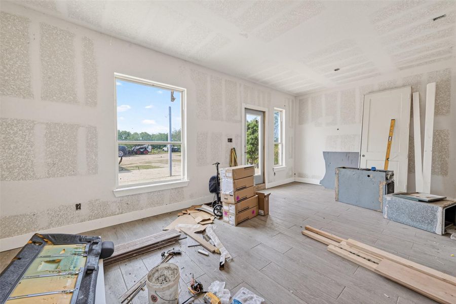 Main-level unfinished interior with open-concept layout, natural light, and construction underway.