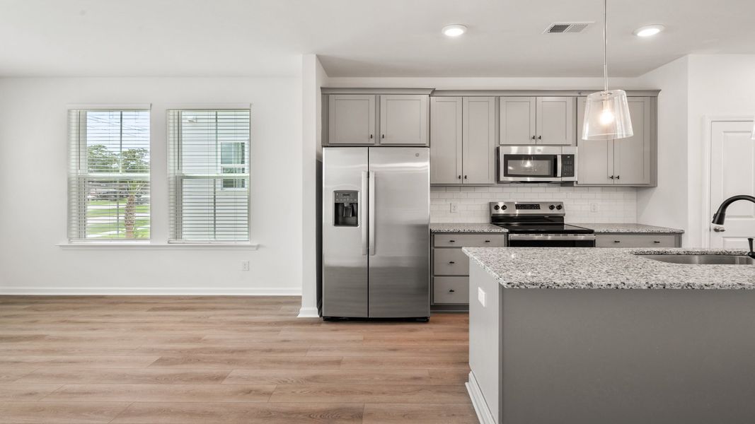 Kitchen in Hayden Floorplan with large island and lots of natural light at Clear Springs Townhomes