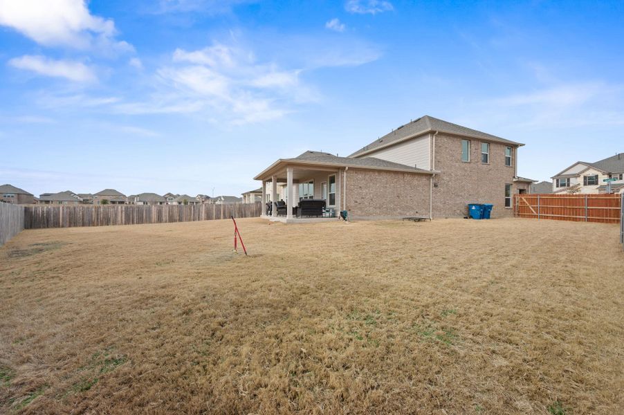 Back of house with a patio, a residential view, a fenced backyard, and brick siding