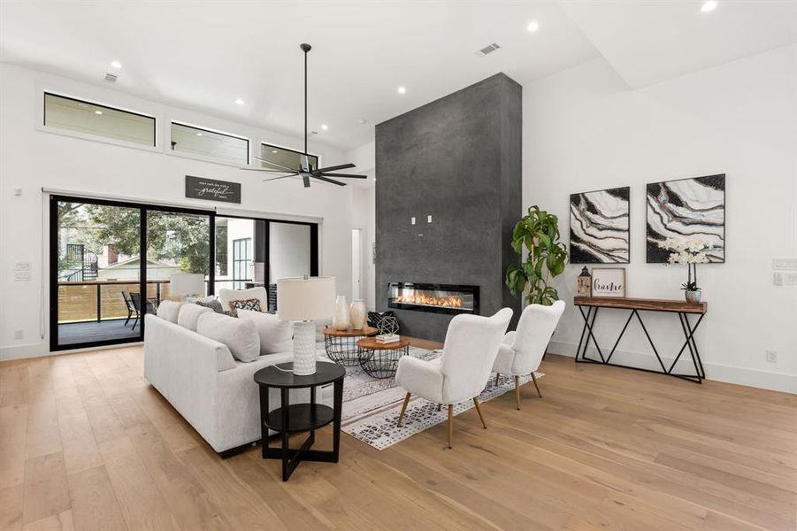 The Luxurious Living Room offers SOARING ceilings, the sliding glass door offers a view of the Beautiful Backyard, and a floor to ceiling fireplace to cozy up to.