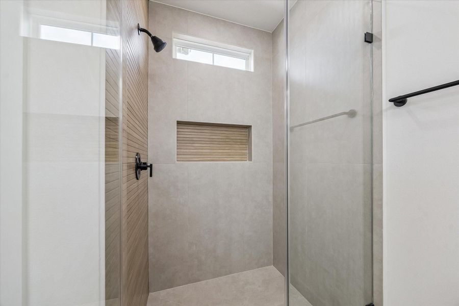 Walk-in shower with modern tile surround and glass enclosure Walk-in shower with modern tile surround and glass enclosure