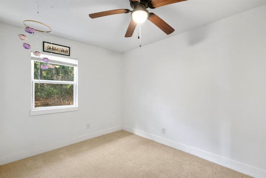 Spare room featuring carpet flooring and ceiling fan