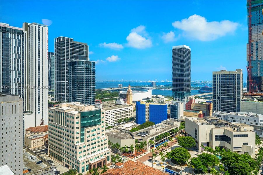 Urban skyline featuring glass-facade high-rise towers, proximity to the coastline, and expansive metropolitan scenery