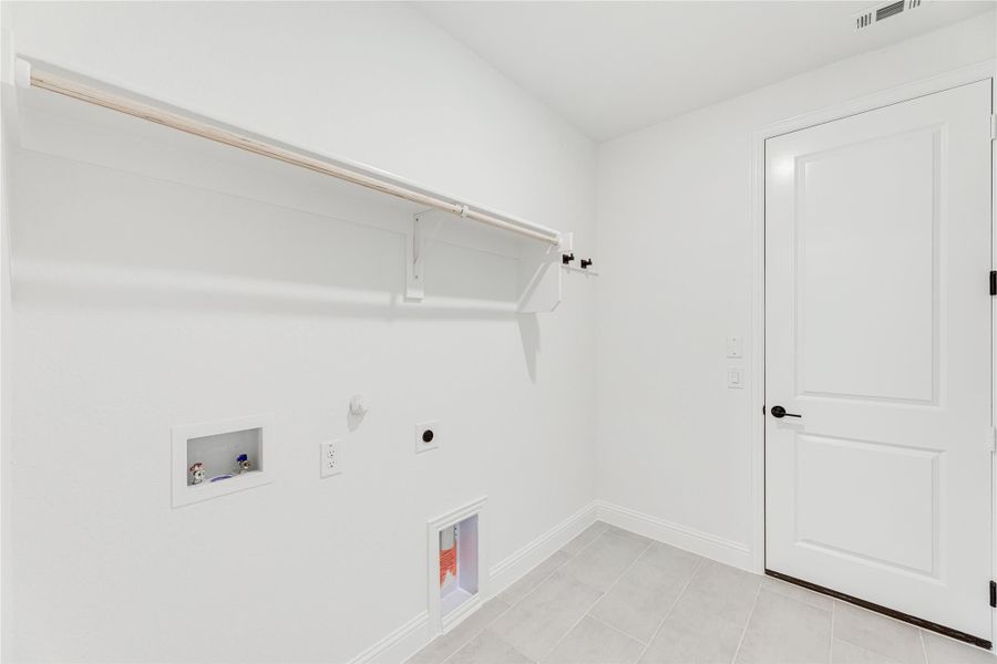 Laundry room with wall-mounted drying rack, washer and dryer hookups, and tile floors