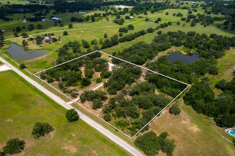 Aerial view of sparsely populated area featuring property parcel outlined...