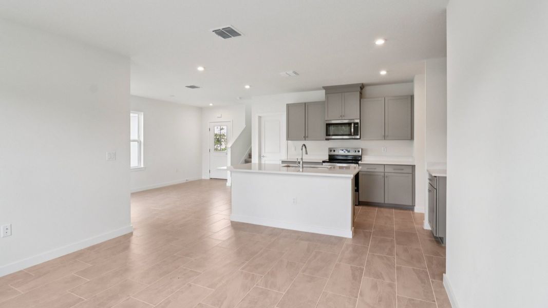 Kitchen and Living Room in the Monterey End Townhome by DRB Homes - Cyrene at Harmony in St Cloud FL
