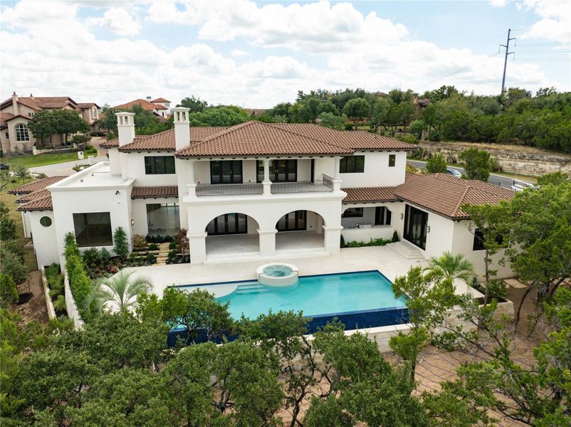 Rear view of property with infinity pool, terrace and summer kitchen