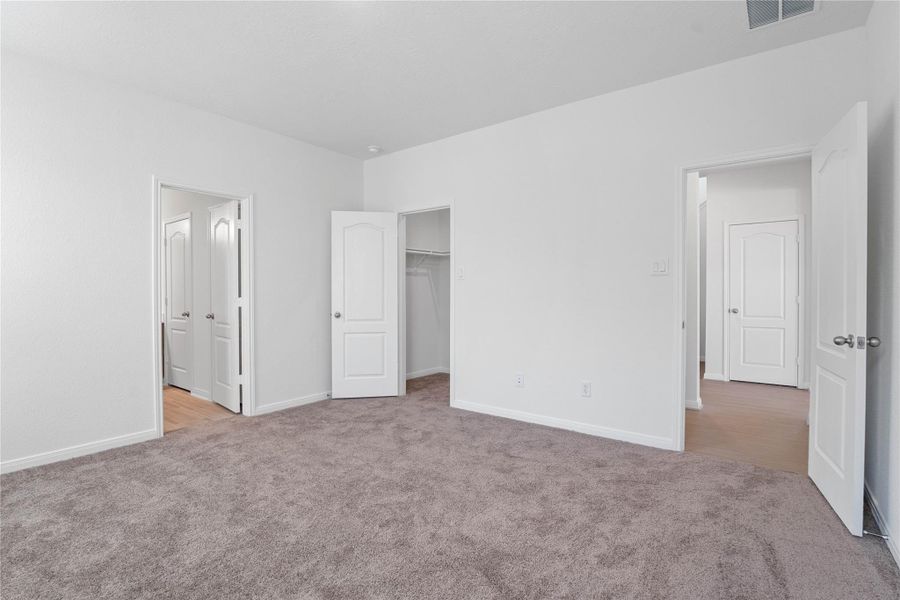 Additional view from the primary bedroom looking towards walk-in closet and ensuite primary bathroom. Additional view from the primary bedroom looking towards walk-in closet and ensuite primary bathroom.