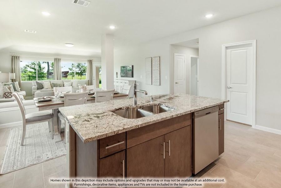 Kitchen island with granite countertop and double sink, open to dining and living areas with large windows.