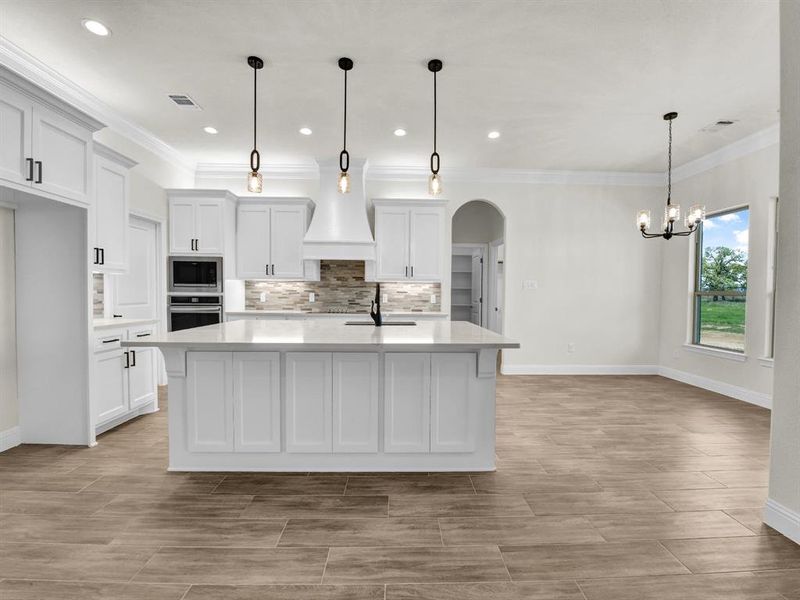 Kitchen with built in microwave, light countertops, visible vents, and oven Kitchen with built in microwave, light countertops, visible vents, and oven