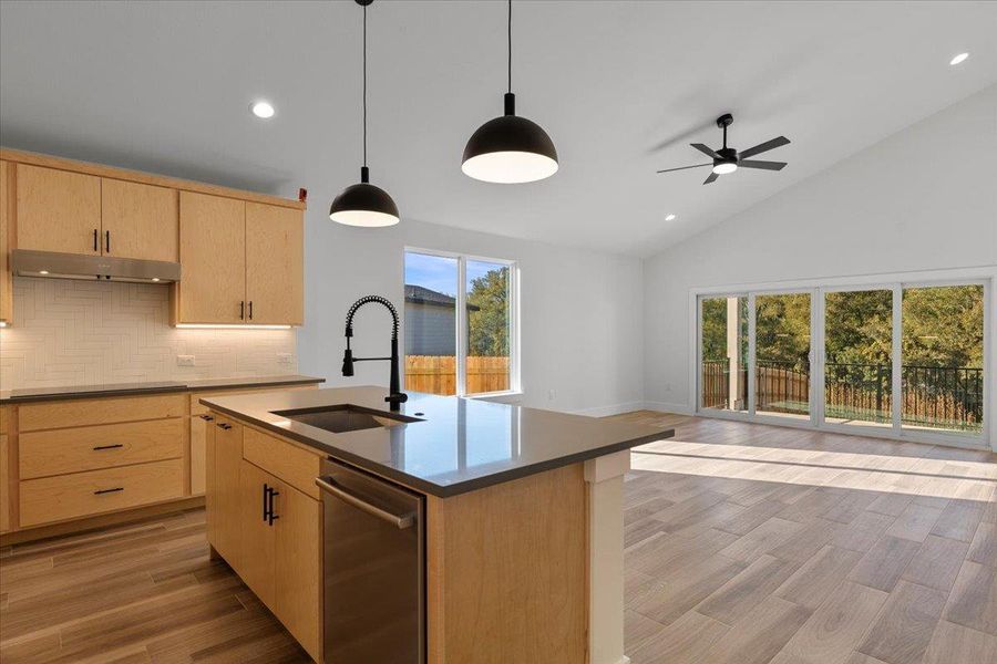 Kitchen featuring light brown cabinetry, recessed lighting, light wood-style flooring, open floor plan, and decorative backsplash Kitchen featuring light brown cabinetry, recessed lighting, light wood-style flooring, open floor plan, and decorative backsplash