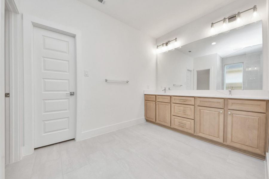 Elevate your daily routine at the elegant vanity, now equipped with double sinks, light countertops, modern hardware, and beautiful vanity lights. Elevate your daily routine at the elegant vanity, now equipped with double sinks, light countertops, modern hardware, and beautiful vanity lights.