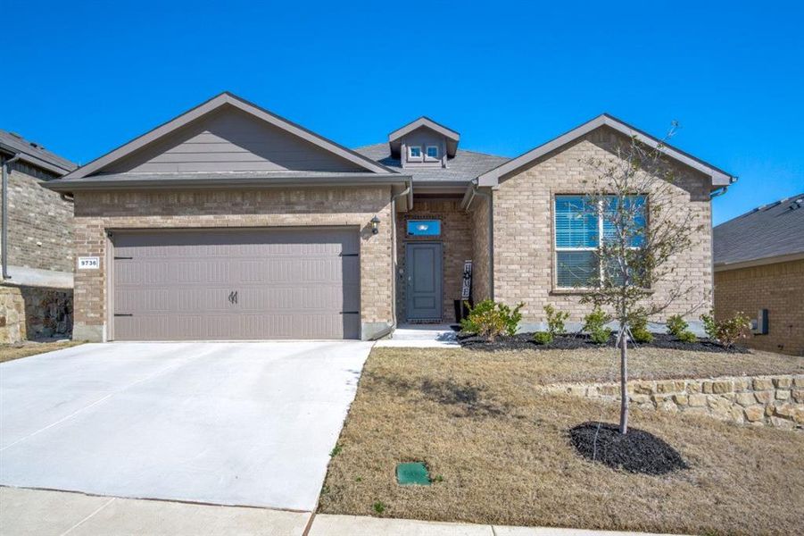 Ranch-style home featuring brick siding, an attached garage, and driveway